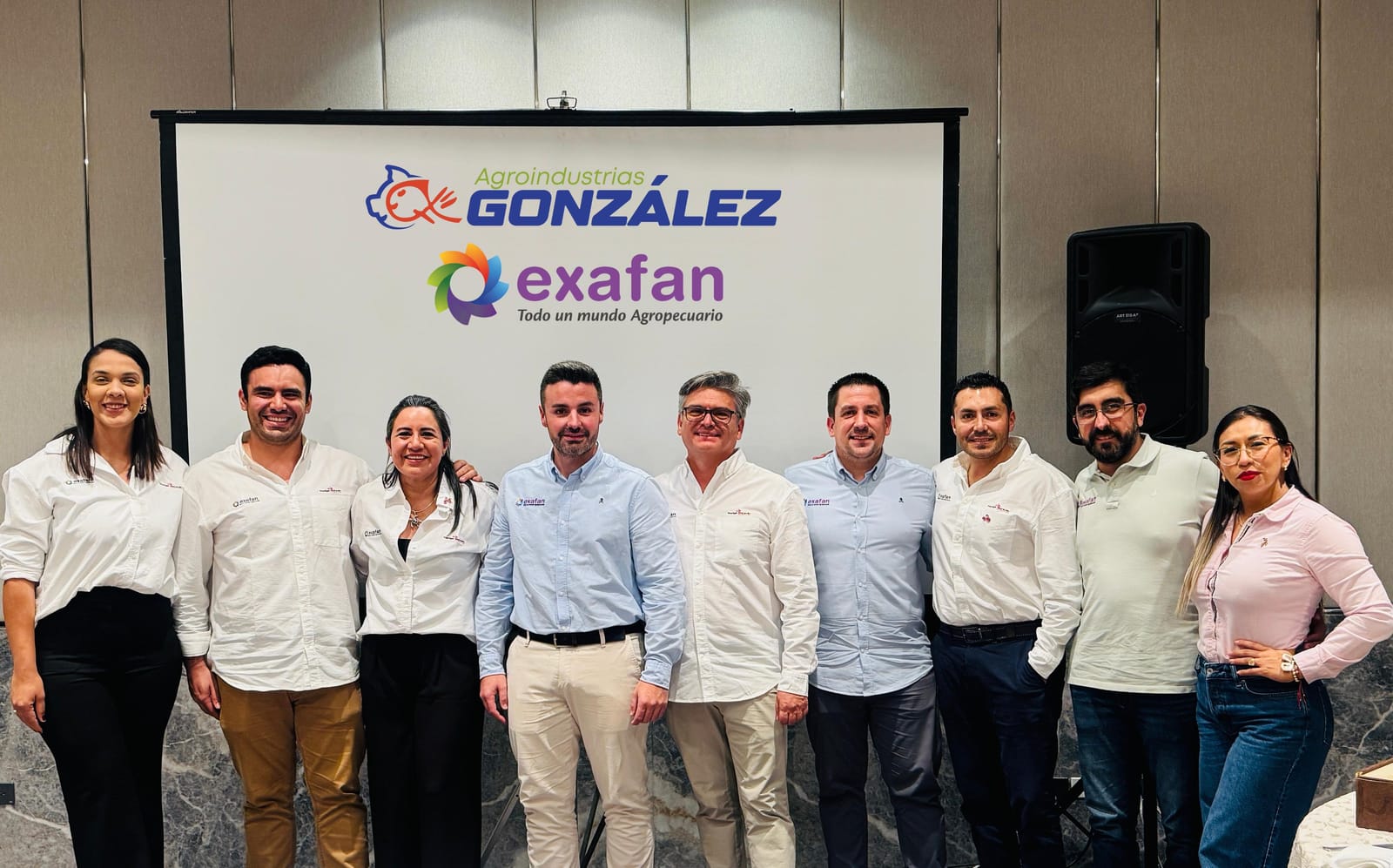 Ocho integrantes del equipo posan ante un panel con los logotipos de Agroindustrias González y de Exafan, durante la presentación de Exafan Ecuador